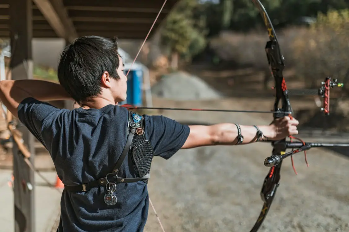 Man shooting compound bow and arrow